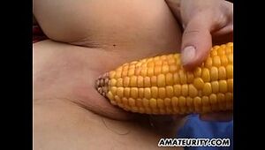 Inexperienced girlfriend toys her puss with corn outdoor